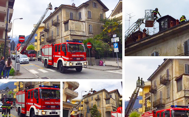 Un pezzo di un camino cade su auto posteggiata. Autoscala dei Vigili del fuoco in azione